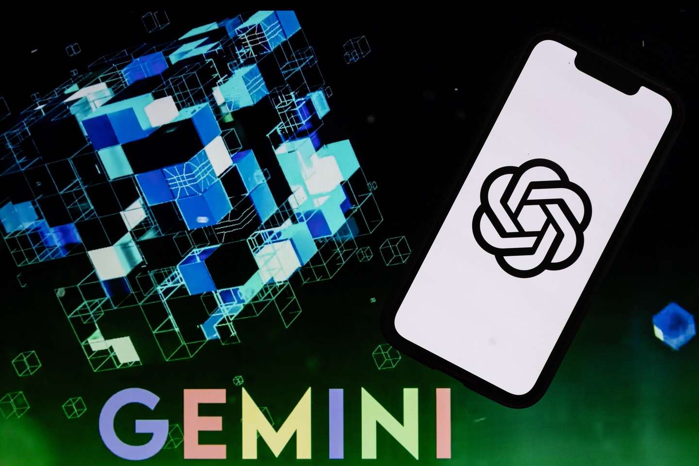 epa10855388 An illustration picture shows a mobile phone displaying the logo of Open AI and Microsoft Corporation’s Chat GPT over a screen displaying the Google Gemini letters, in Los Angeles, USA, 11 September 2023. Semiconductor research company, SemiAnalysis, estimates in a recent publication on their online platform that the Google AI, GEMINI, would be five times more powerful than Open AI and Microsoft Chat GPT.  EPA/ETIENNE LAURENT