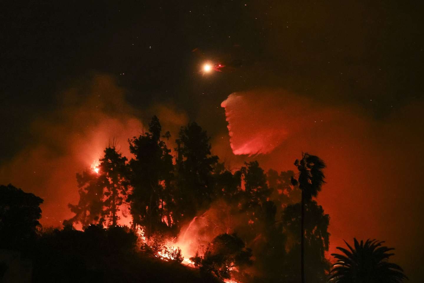 epa11814027 A plane drops water on a section of the Sunset wildfire in Los Angeles, California, USA, 08 January 2025. According to data from California Department of Forestry and Fire Protection (CAL FIRE) multiple wildfires are burning across thousands of acres and forcing thousands of evacuations and destroying hundreds of homes in the Los Angeles area.  EPA/ALLISON DINNER