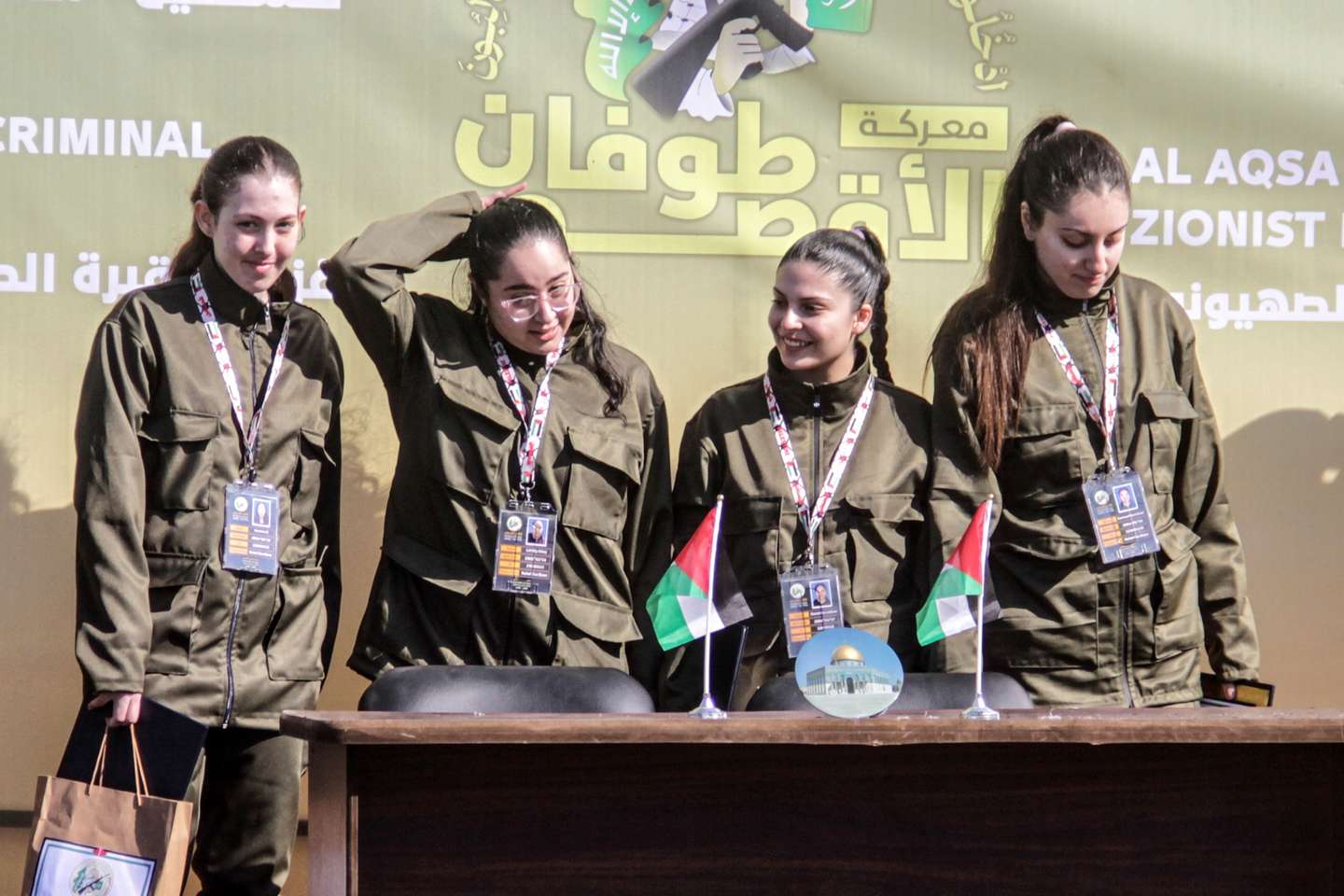 epa11851278 (L-R) Israeli hostages Naama Levy, Liri Albag, Daniella Gilboa and Karina Ariev stand on a stage before being delivered to the representative of the International Committee of the Red Cross (ICRC) by Hamas militants, as they are released from the Gaza Strip, in Gaza City, 25 January 2025. The four Israeli hostage soldiers Liri Albag, Naama Levy, Karina Ariev, and Daniella Gilboa, were taken hostage from an intelligence outpost near the Israeli Gaza border during the Hamas-led attack on 07 October 2023. Israel and Hamas implemented the first phase of a hostage release and ceasefire deal on 19 January 2025.  EPA/MAHMOUD ZAKI