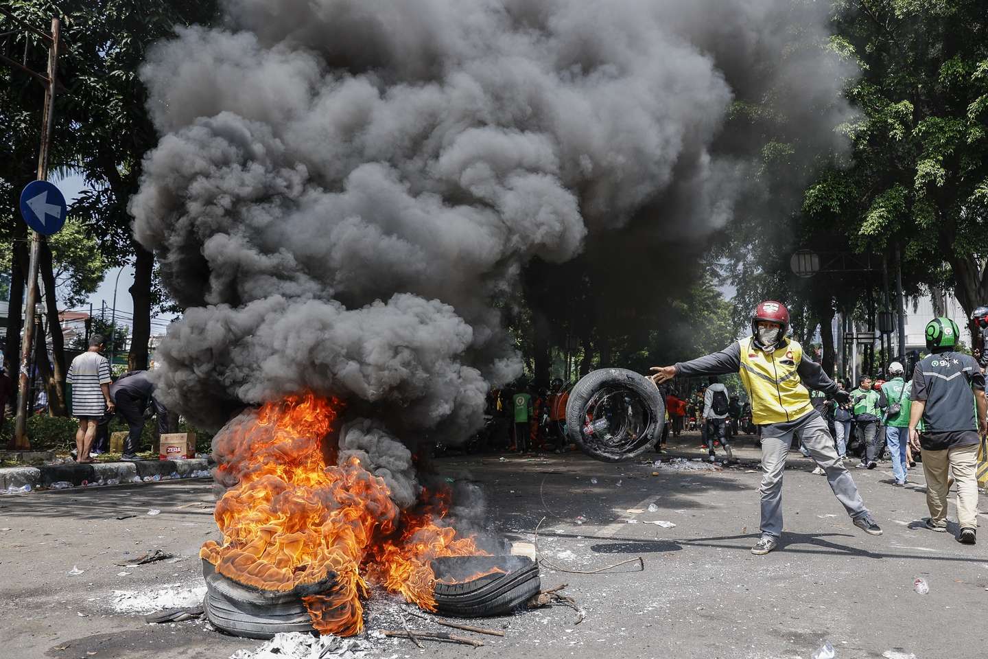 epa12332464 A protester burns tyers after clashing with police outside the Mobile Brigade police headquarters in Jakarta, Indonesia, 29 August 2025. Hundreds of protesters and motorbike-hailing drivers staged a protest following the death of a motorbike-hailing driver during an earlier demonstration against the housing allowance for members of parliament.  EPA/MAST IRHAM