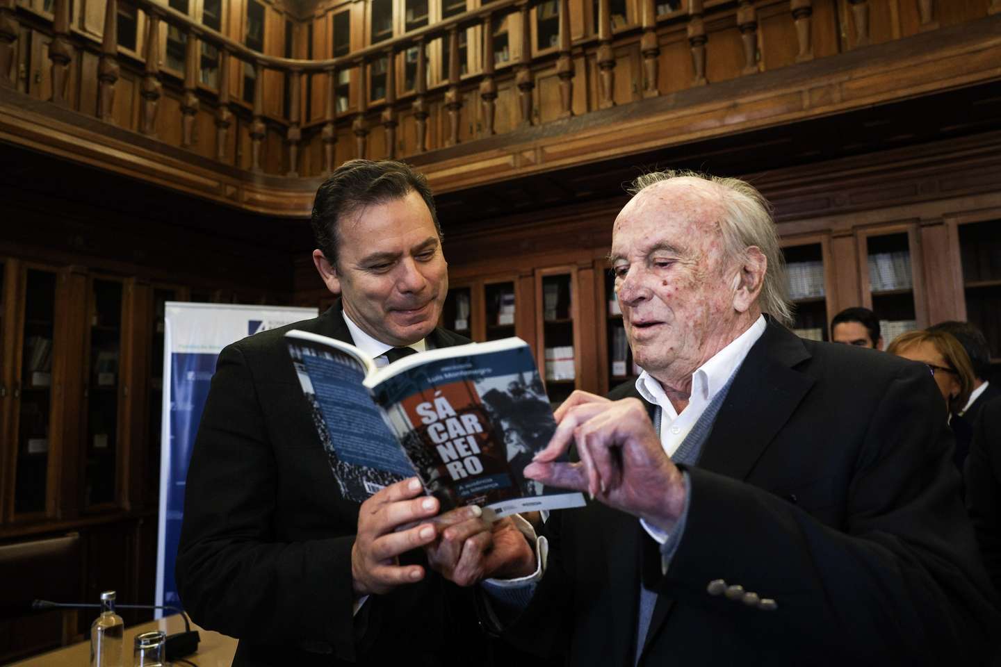 O presidente do Partido Social Democrata (PSD), Luis Montenegro, conversa com um dos fundadores do seu partido, Francisco Pinto Balsemão, na sessão de apresentação do livro: Francisco Sá Carneiro, na Assembleia da República em Lisboa, 02 de março de 2023. TIAGO PETINGA/LUSA