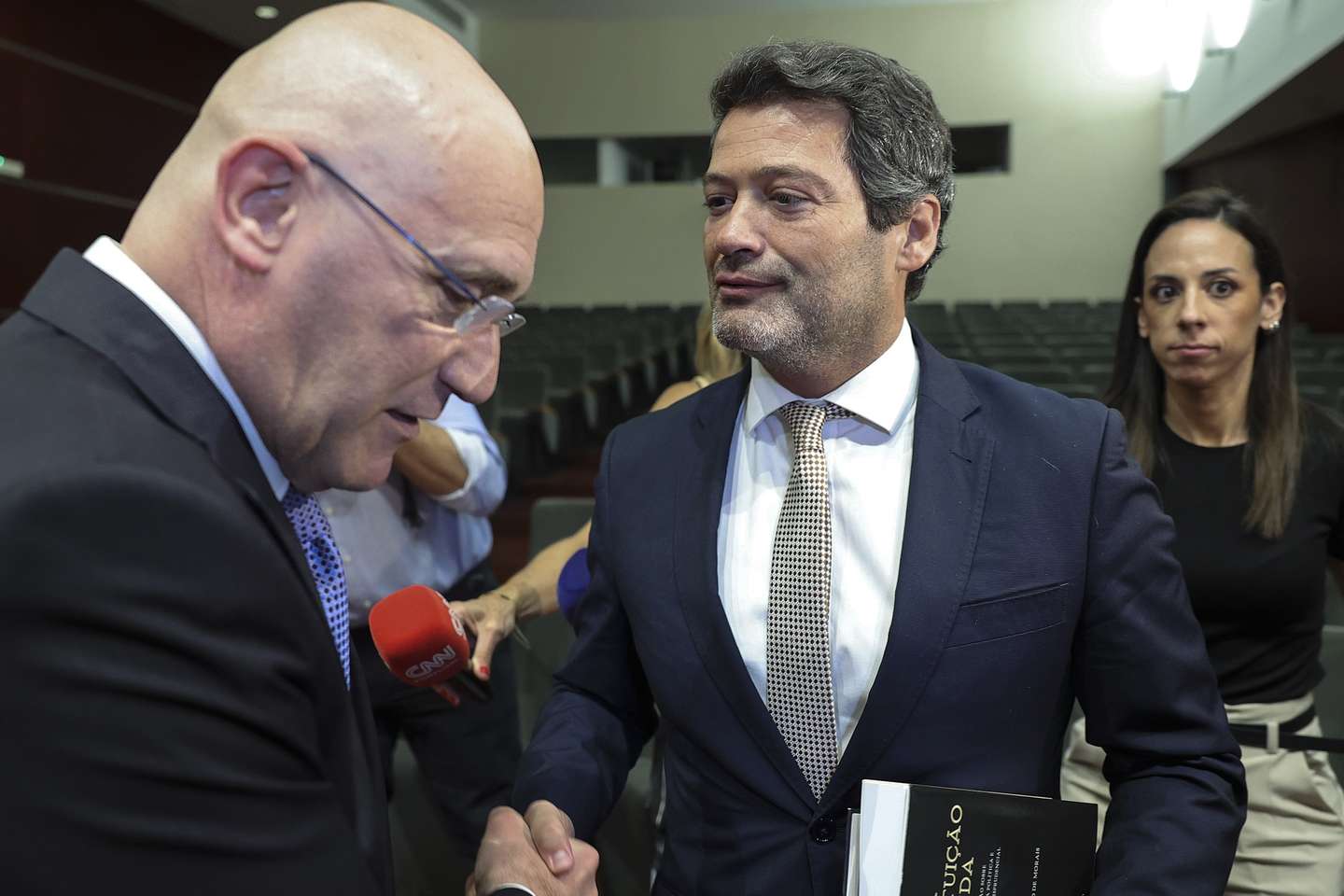 O presidente do Chega, André Ventura (D), cumprimenta o antigo primeiro-ministro Pedro Passos Coelho, durante o lançamento do livro "A Constituição Fluida", no auditório da Faculdade de Direito de Lisboa, 26 de maio de 2026. MANUEL DE ALMEIDA/LUSA