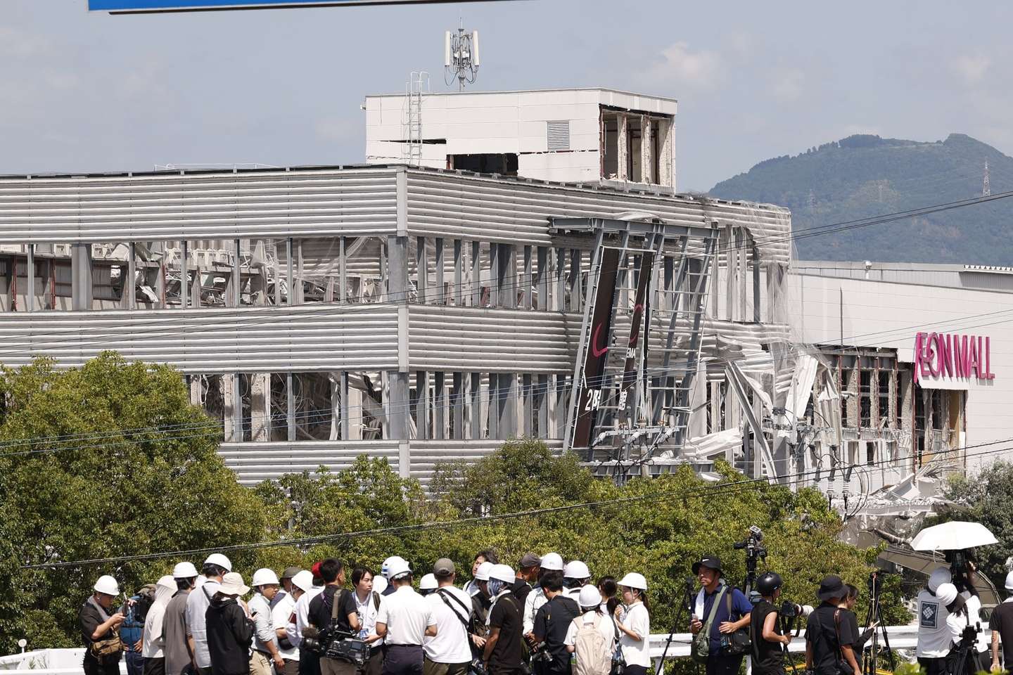 epa13140934 Media members report in front of the Aeon Mall Kumamoto building which was damaged by an explosion following a powerful earthquake in Kashima, Kumamoto Prefecture, southwestern Japan, 30 July 2026.  Rescue operations continue across Kumamoto Prefecture, where 28 people have died and several others were injured following a 7.1-magnitude earthquake that damaged critical infrastructure, including a shopping mall and an industrial plant, according to Japan's Chief Cabinet Secretary Minoru Kihara.  EPA/RODRIGO REYES MARIN