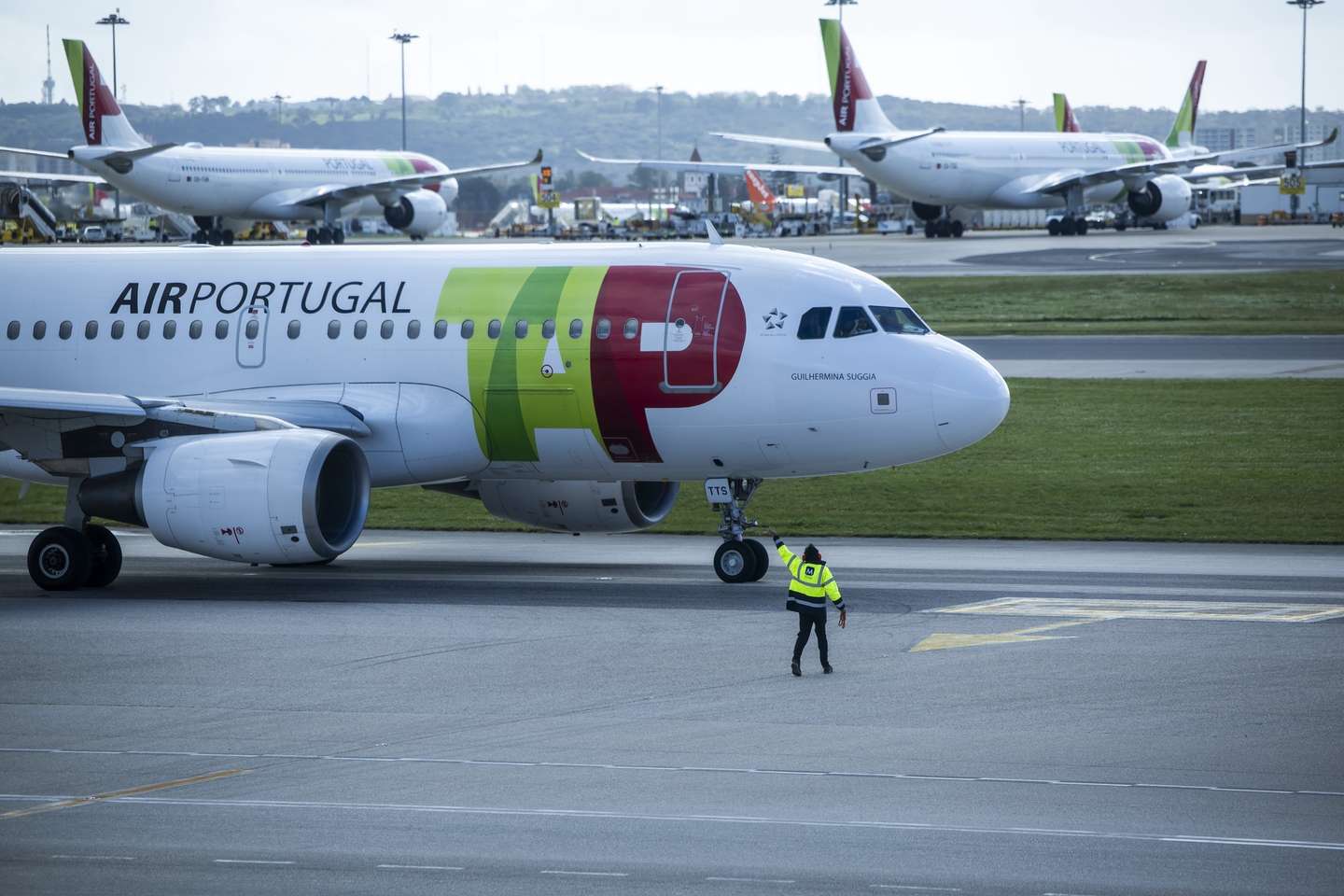 Um trabalhador de placa dá indicações a um piloto num avião da TAP, no Aeroporto Humberto Delgado, em Lisboa, 15 de abril de 2025.  JOSÉ SENA GOULÃO/LUSA