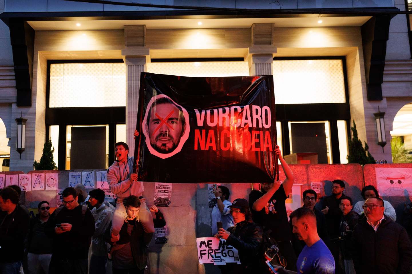 epa12672961 People hold signs that reads 'Vorcaro in Jail' with the portrait of former owner of Banco Master Daniel Vorcaro during a protest organized by the Free Brazil Movement (MBL) against Banco Master following recent fraud allegations published in the press, in front of the bank's headquarters in Sao Paulo, Brazil, 22 January 2026. The bank was recently liquidated and the area has been fenced off.  EPA/Isaac Fontana