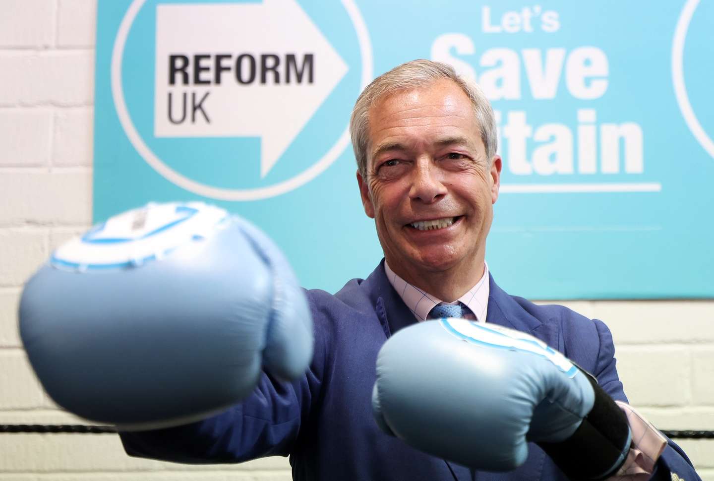 epa11455061 Reform UK leader Nigel Farage wearing boxing gloves as he visits a boxing gym with British heavyweight boxer Derek Chisora (not seen) in Clacton, Britain, 03 July 2024. The UK is set to hold a general election on 04 July.  EPA/ANDY RAIN