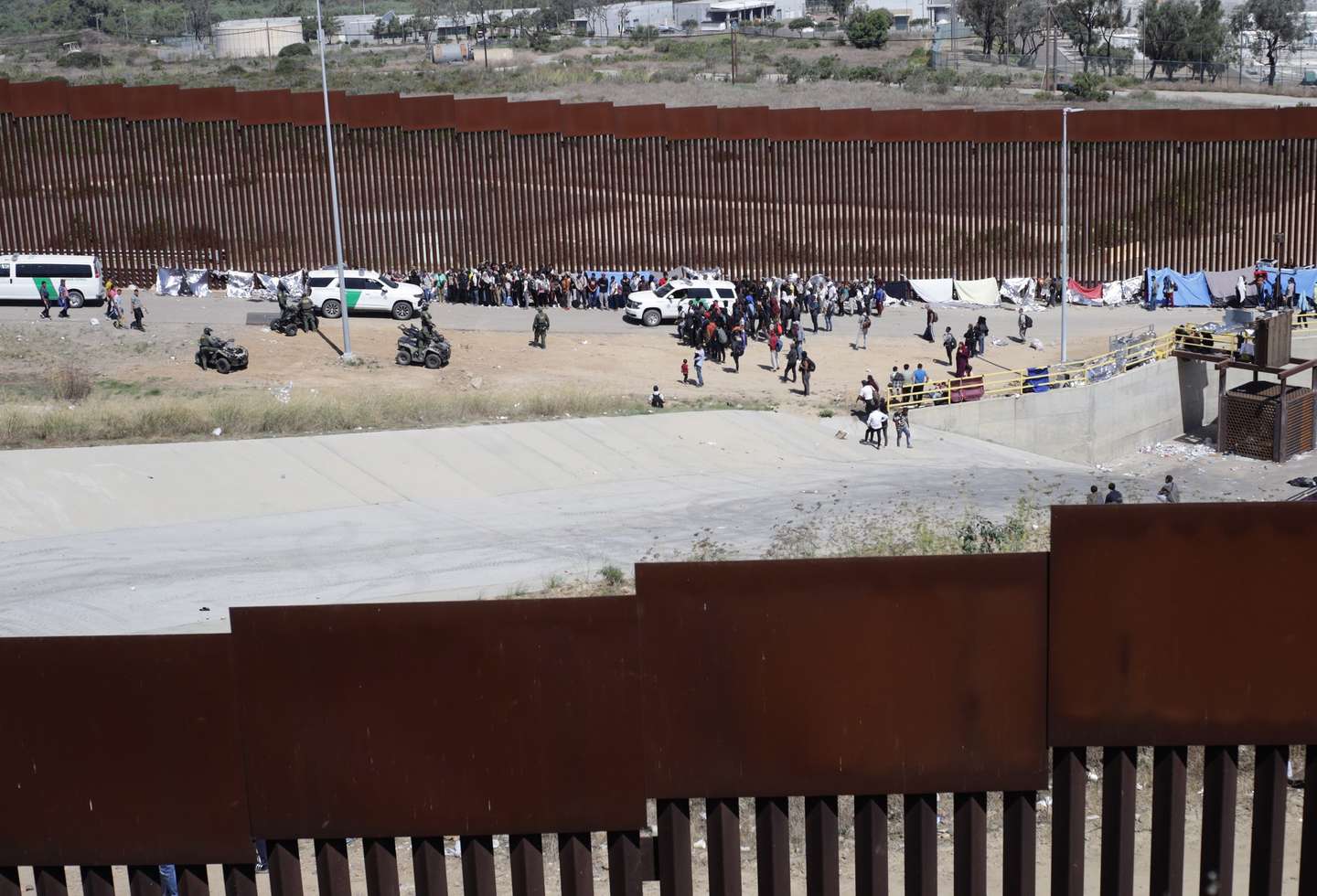 epa10877631 Migrants camp next to the US border wall in Tijuana, Baja California, Mexico, 22 September 2023. The variety of nationalities of migrants who cross through Mexico to reach the United States is increasing because more people are leaving their countries after the covid-19 pandemic, which has caused a new wave of migration in the region, indicated the International Organization for Migration (IOM).  EPA/JOEBETH TERRIQUEZ