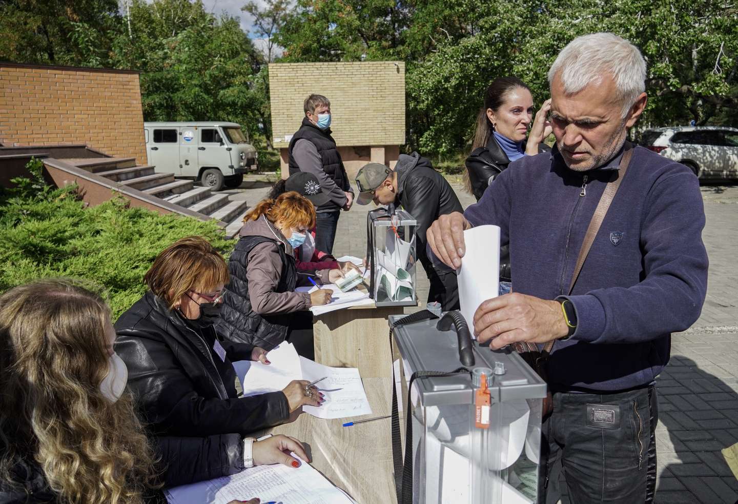 epaselect epa10206095 A man casts his ballot during a referendum on the joining of Russian-controlled regions of Ukraine to Russia, at an outdoor polling station in Mariupol, eastern Ukraine, 25 September 2022. From 23 to 27 September, residents of the self-proclaimed Luhansk and Donetsk People's Republics as well as the Russian-controlled areas of the Kherson and Zaporizhzhia regions of Ukraine vote in a referendum to join the Russian Federation. On 24 February 2022 Russian troops entered the Ukrainian territory in what the Russian president declared a 'Special Military Operation', starting an armed conflict that has provoked destruction and a humanitarian crisis.  EPA/STRINGER