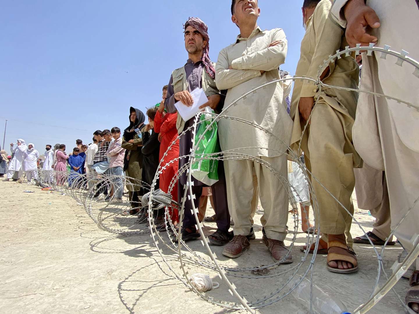 epa09417769 Afghans including those who worked for the US, NATO, Europe Union and the United Nations in Afghanistan wait outside the Hamid Karzai International Airport to flee the country, after Taliban took control of Kabul, Afghanistan, 17 August 2021. Several people were reportedly killed at Kabul airport on 16 August as Afghans were attempting to hang on a moving US military plane leaving the airport. Taliban co-founder Abdul Ghani Baradar earlier in the day declared victory and an end to the decades-long war in Afghanistan, a day after the insurgents entered Kabul to take control of the country. Baradar, who heads the Taliban political office in Qatar, released a short video message after President Ashraf Ghani fled and conceded that the insurgents had won the 20-year war.  EPA/STRINGER