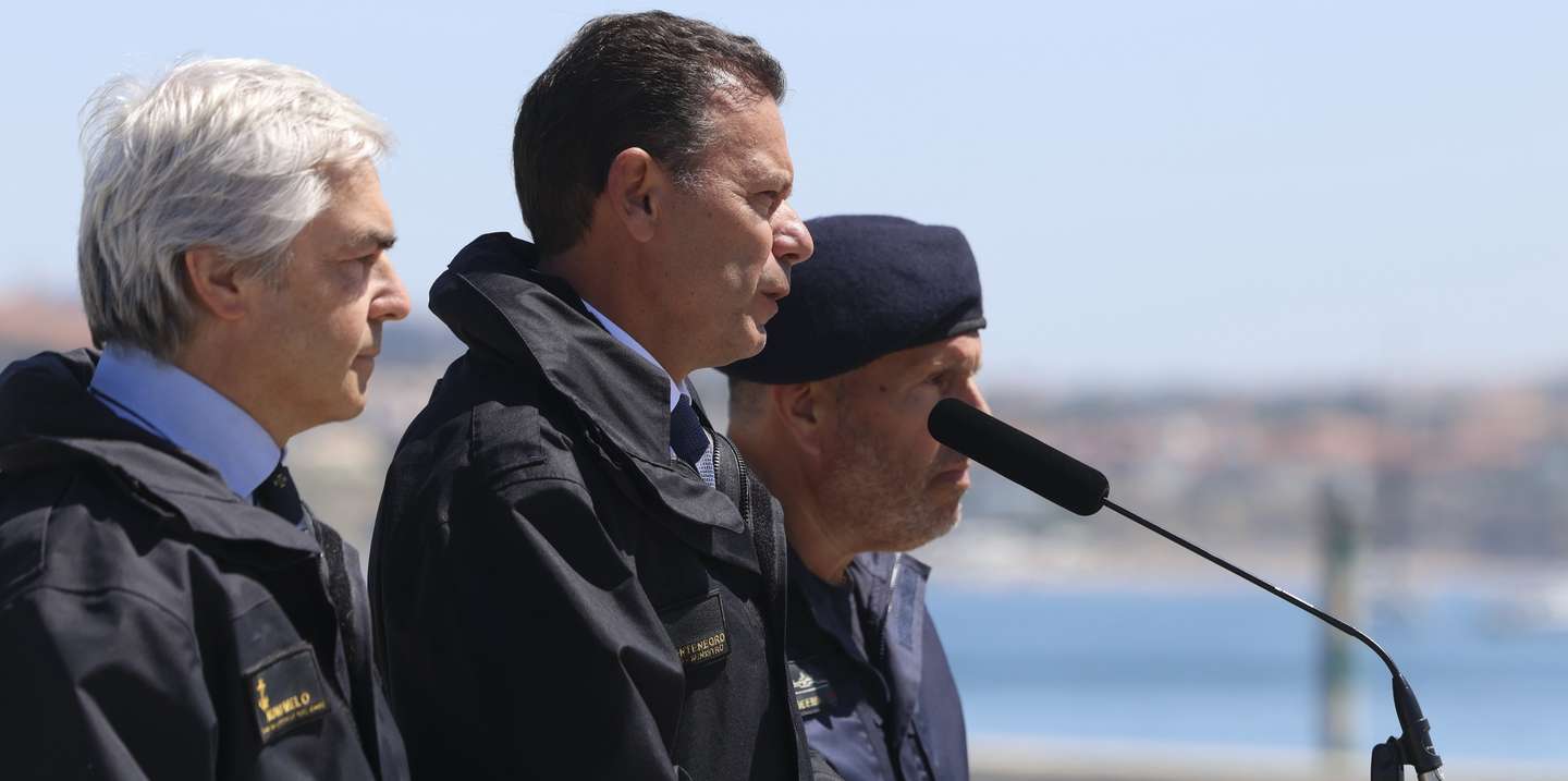 O primeiro-ministro, Luís Montenegro (C), ladeado pelo ministro da Defesa, Nuno Melo (E), discursa durante o acompanhamento das operações do navio-patrulha oceânico NRP Setúbal da Marinha Portuguesa ao largo de Cascais, 12 de agosto de 2026. TIAGO PETINGA/LUSA