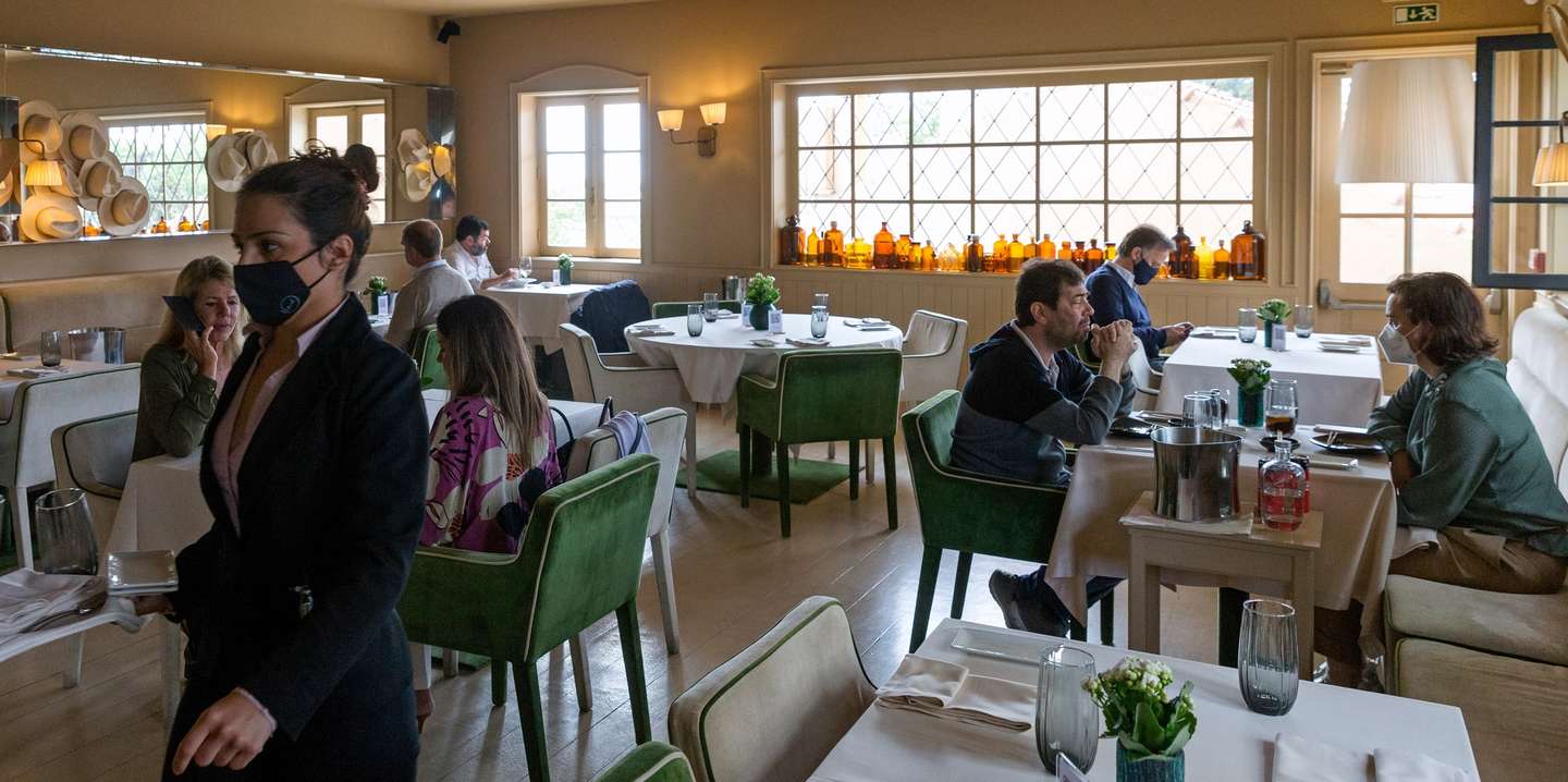 Clientes almoçam no interior do restaurante 'Wish', no dia em que entram em vigor novas medidas de desconfinamento, no Porto, 19 de abril de 2021. Passa a ser autorizada a abertura de restaurantes, cafés e pastelarias, mas com a restrição de lotação máxima a quatro pessoas ou seis pessoas em esplanadas e com horário até às 22:00 horas ou às 13:00 ao fim de semana. JOSÉ COELHO/LUSA
