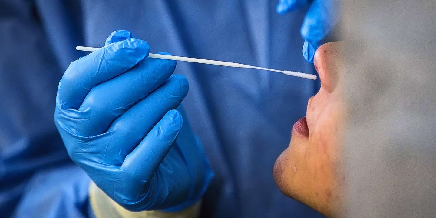 epa08811788 A Healthcare worker, wearing a protective suit, performs a Covid-19 swab test at the Roma Termini Binario95 social hub test center, during the Coronavirus Covid-19 pandemic emergency in Rome, Italy, 10 November 2020. The social hub Binario95, located at the central Roma Termini station, provides coronavirus tests for homeless people, care workers and volunteers.  EPA/ANGELO CARCONI  ATTENTION: This Image is part of a PHOTO SET