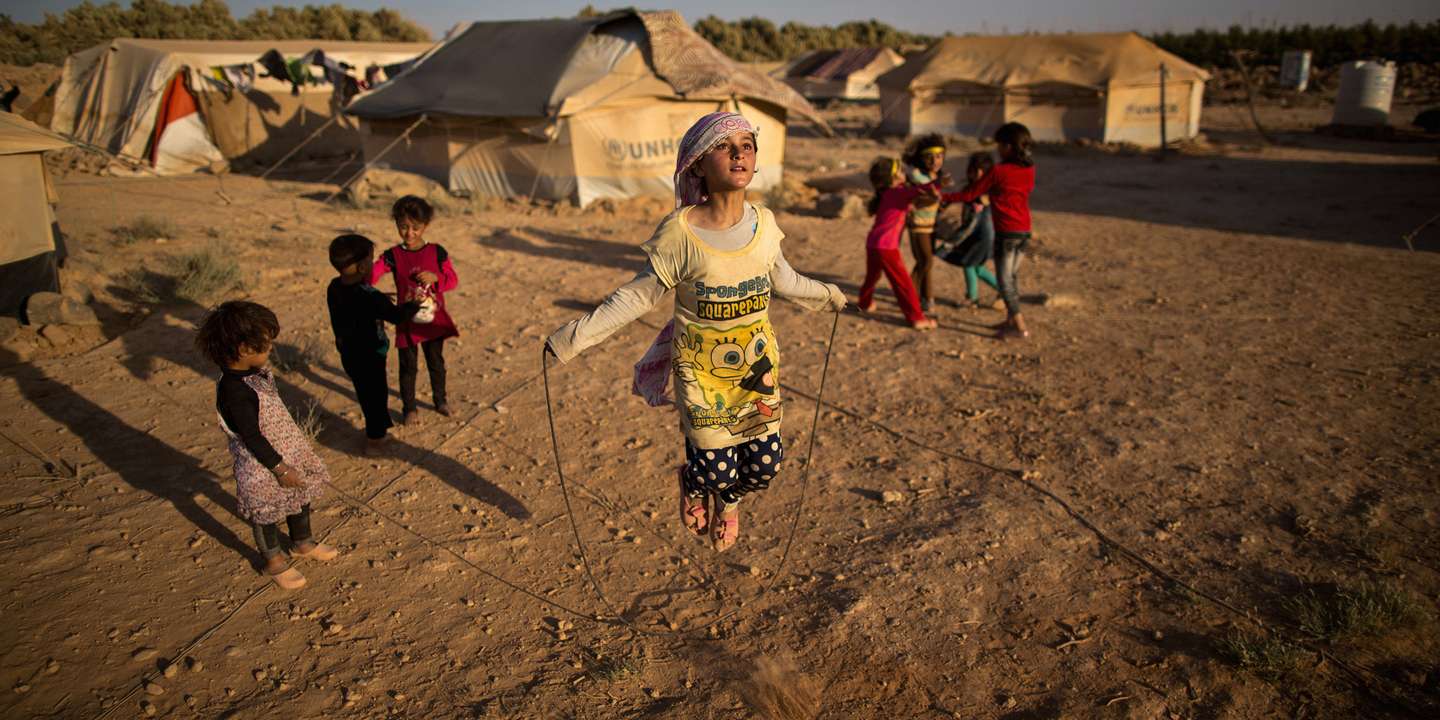 Zubaida Faisal, uma menina refugiada síria de 10 anos, salta à corda com outras crianças perto das suas tendas, num acampamento nos arredores de Mafraq, Jordânia
