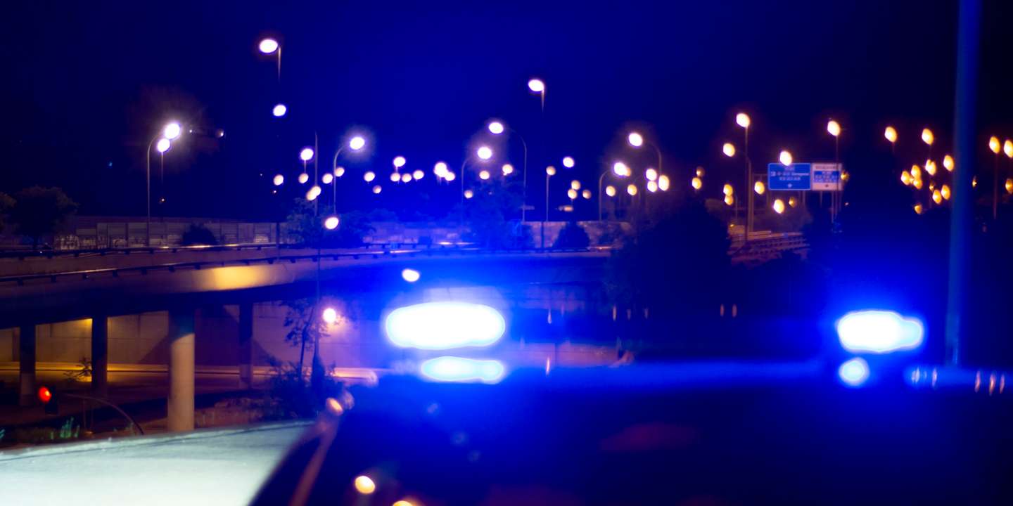 Police car with bright sirens and the city in the background