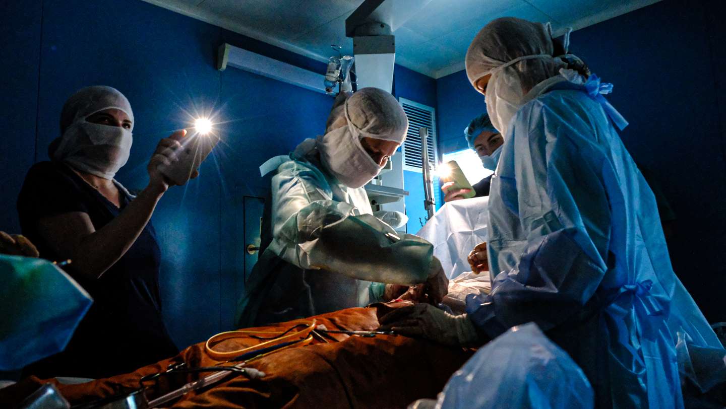 Doctors operate with phone flashlights after power outages in Kyiv