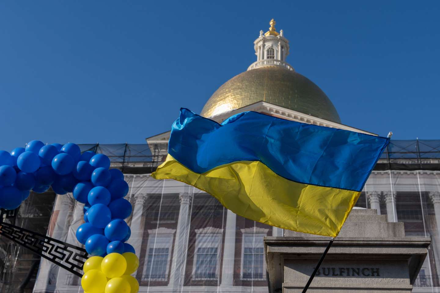 A Ukrainian flag is waved in the air in front of the