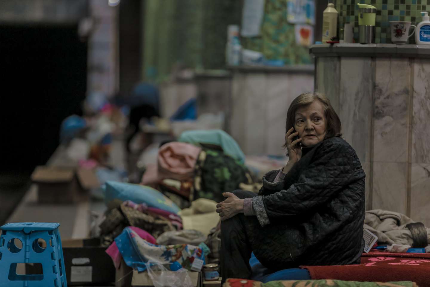 An elderly woman communicates on a phone in the metro