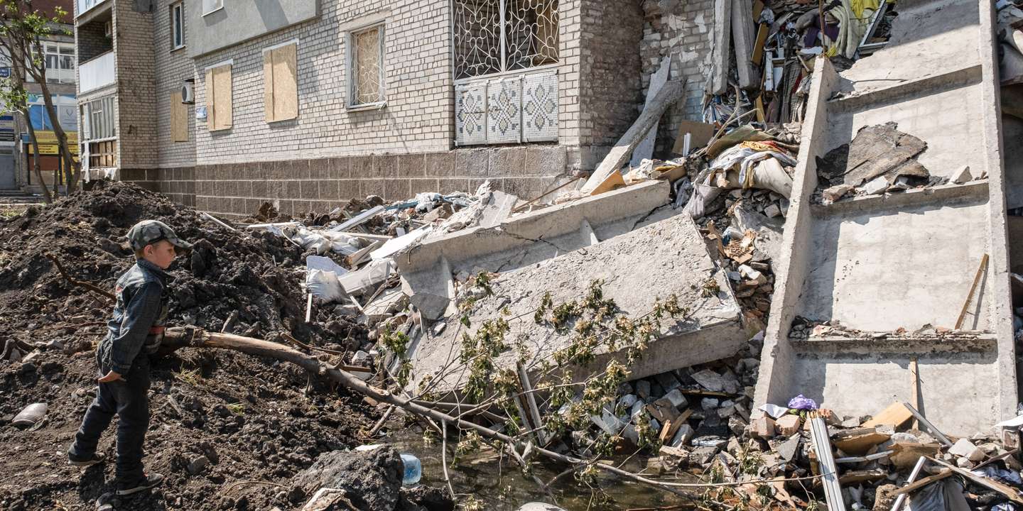 A child observes the ruins of a residential building
