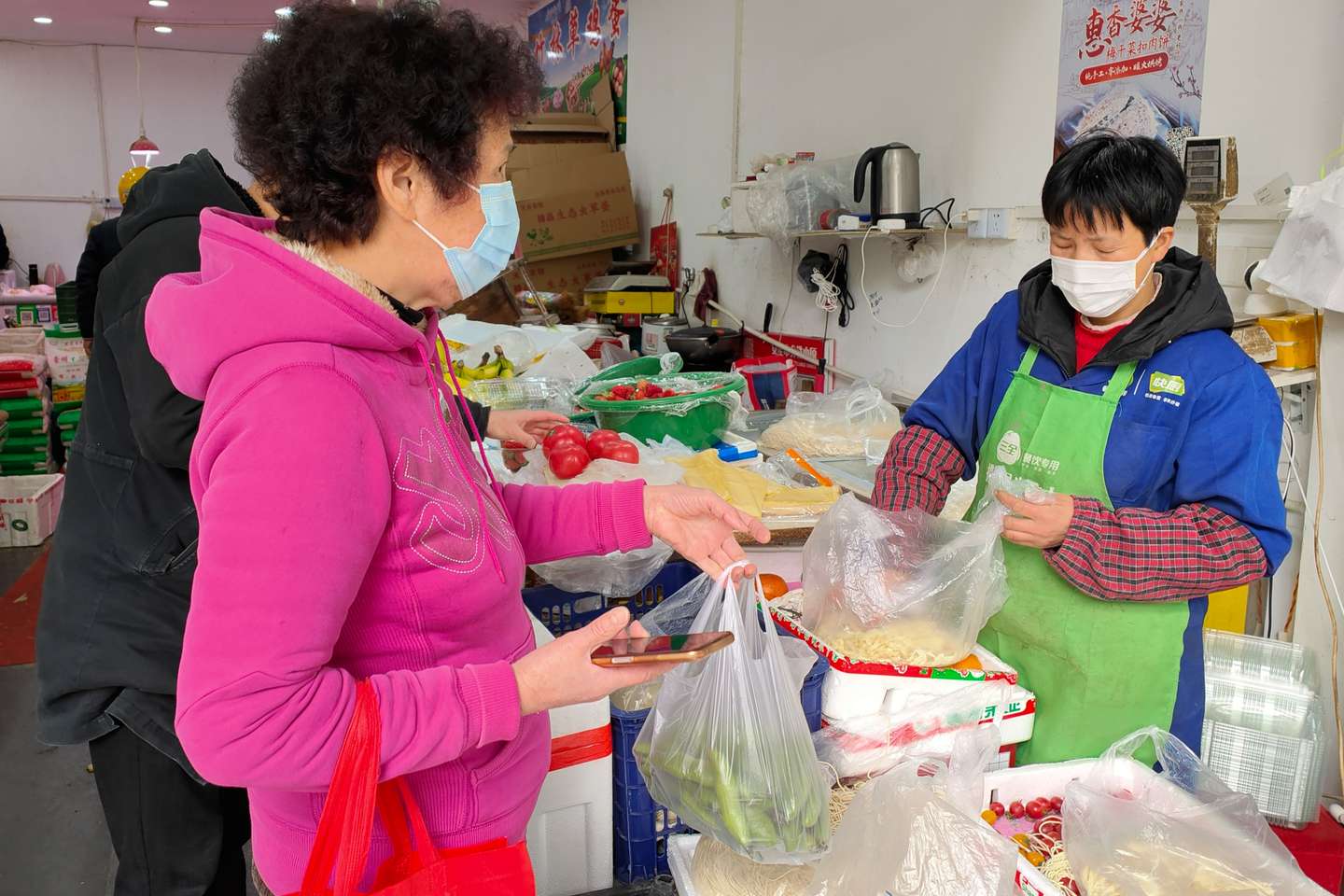 Habitantes no distrito de Yangpu, em Xangai, dirigem-se ao supermercados para comprar alimentos para os dias de confinamento