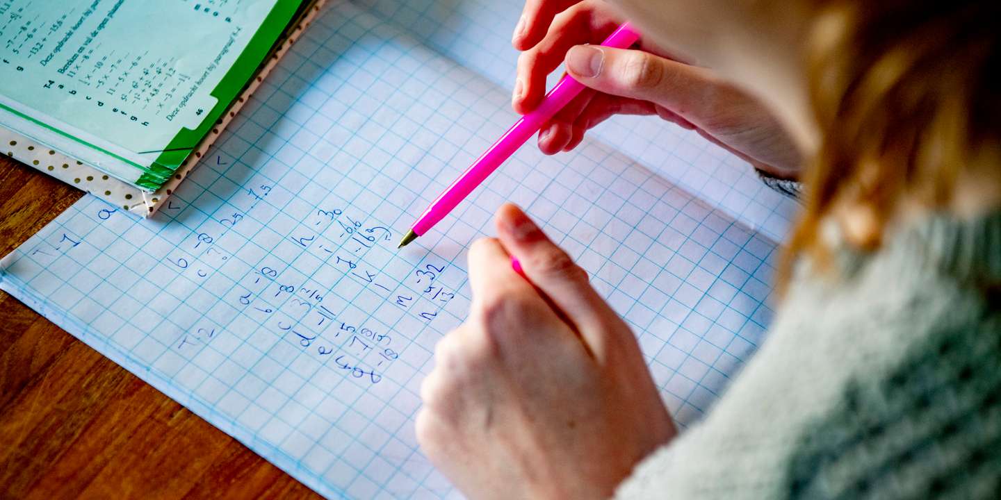 A female student does her mathematics exercises at her home