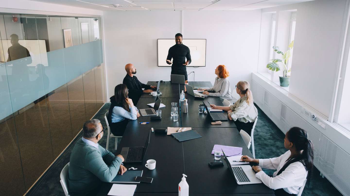 High angle view of businessman giving presentation colleagues in board room at office
