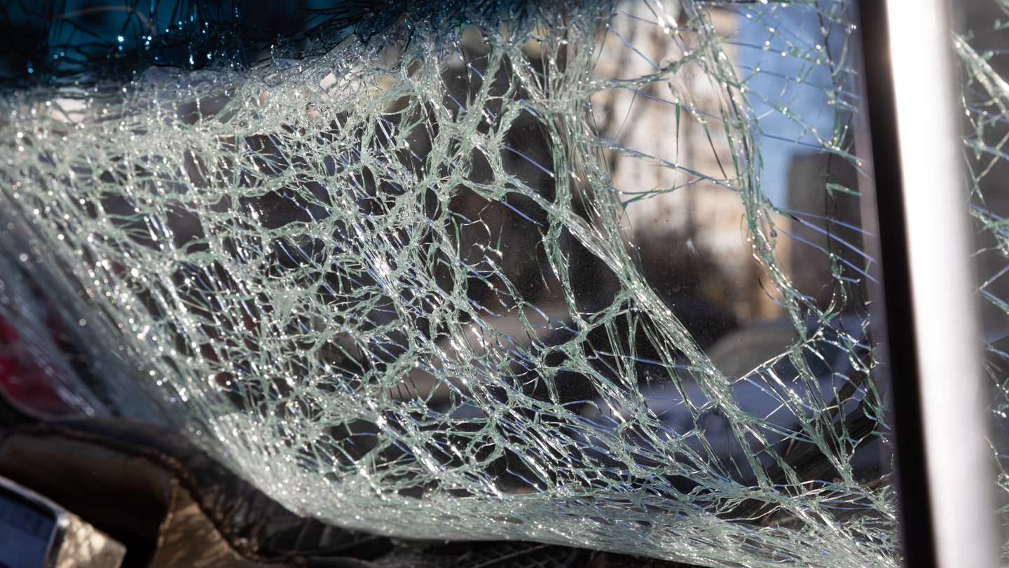 The front windscreen of a car is broken due to the falling
