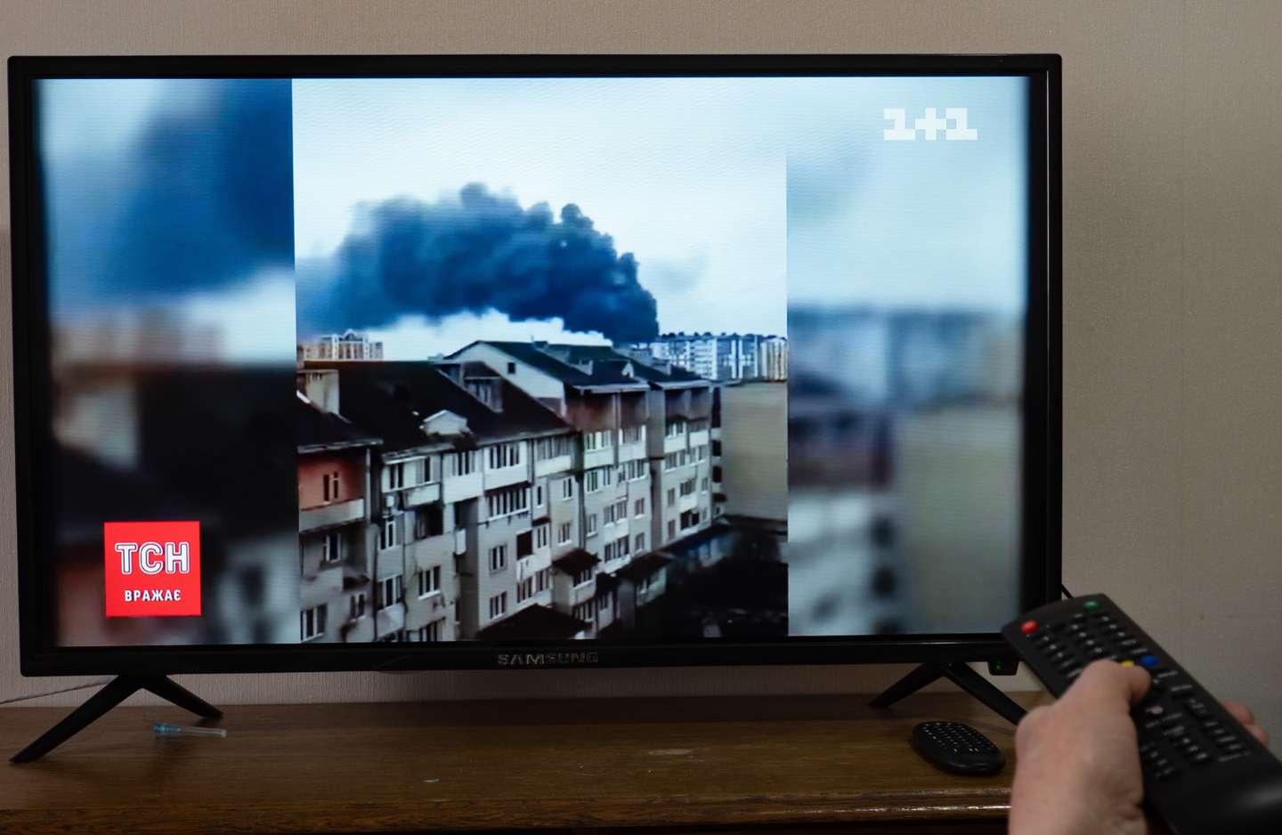 A television screen showing news reports on the shelling of