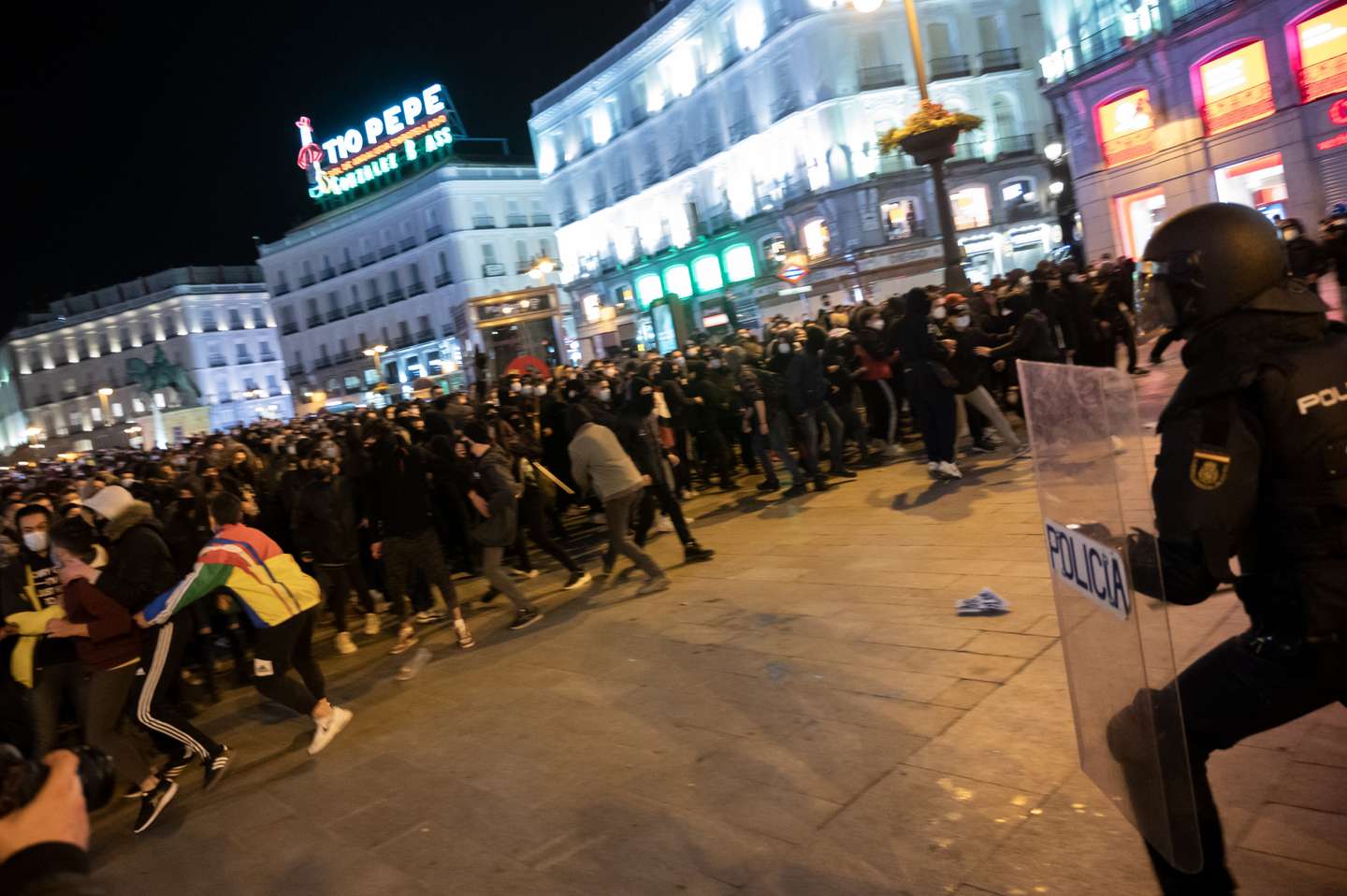 Riot police chasing protesters during a demonstration