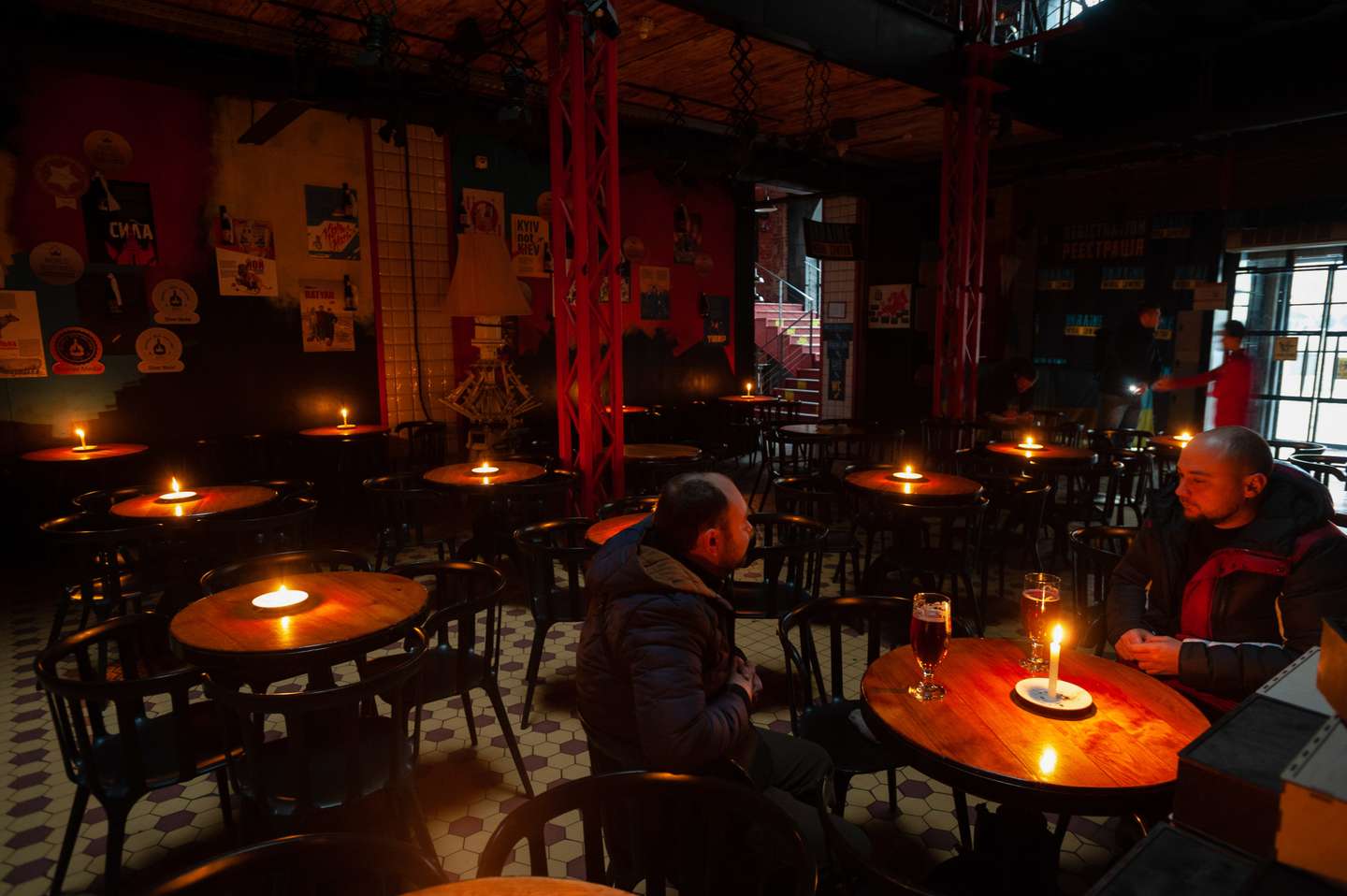 People sit at a restaurant illuminated with lit candles