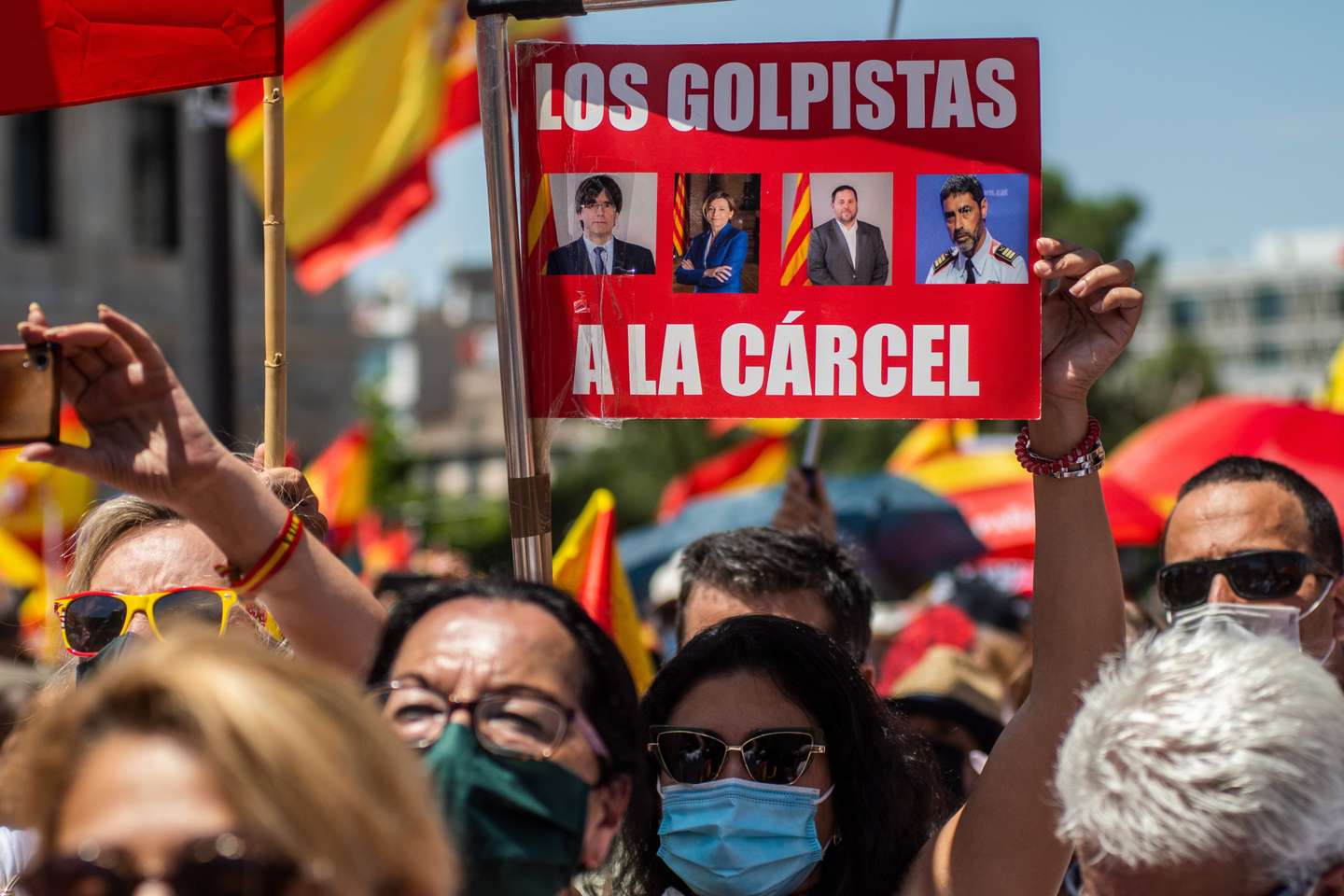 Protesters carrying placards and Spanish flags during a