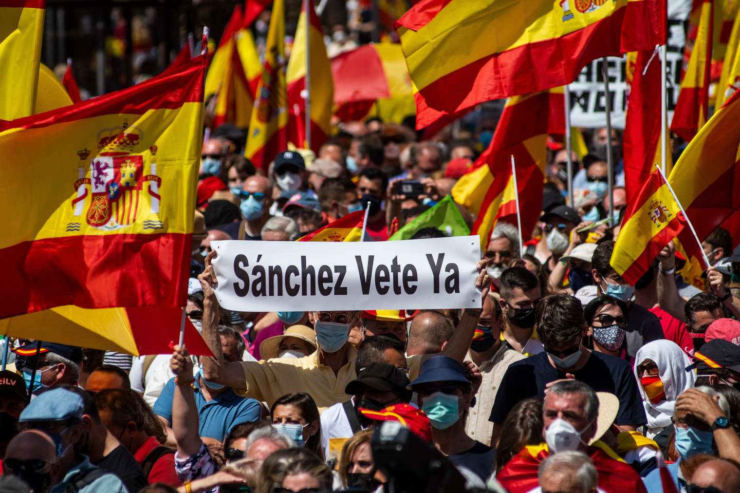 Protesters carrying placards and Spanish flags during a