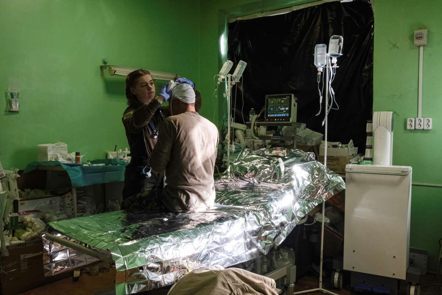 A doctor medicates a soldier with a head injury