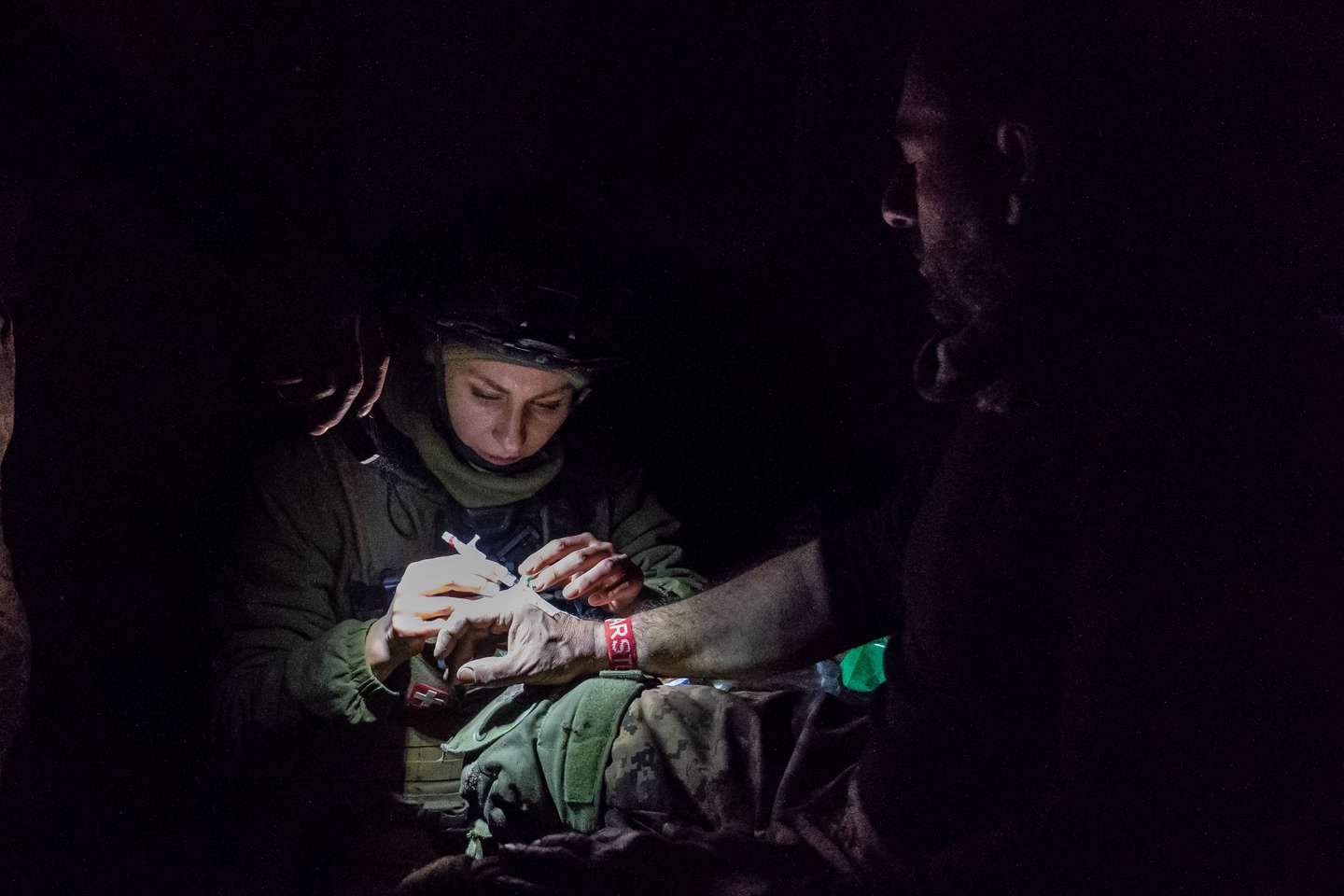 A paramedic attends to an injured solider at a medical point