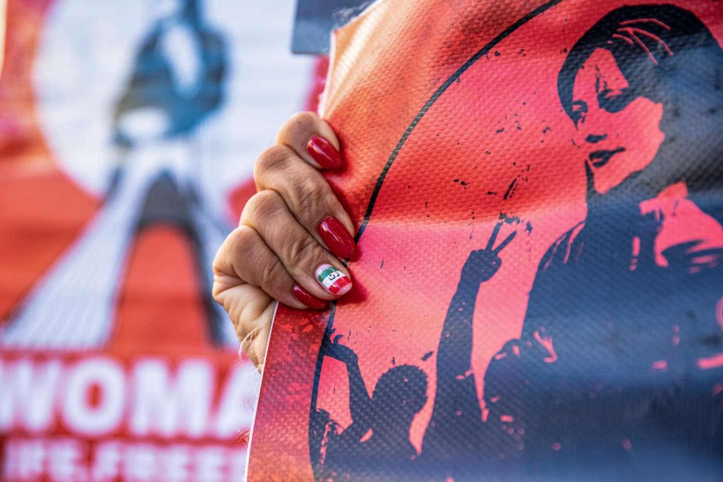A protester with varnished nails in the colours of the