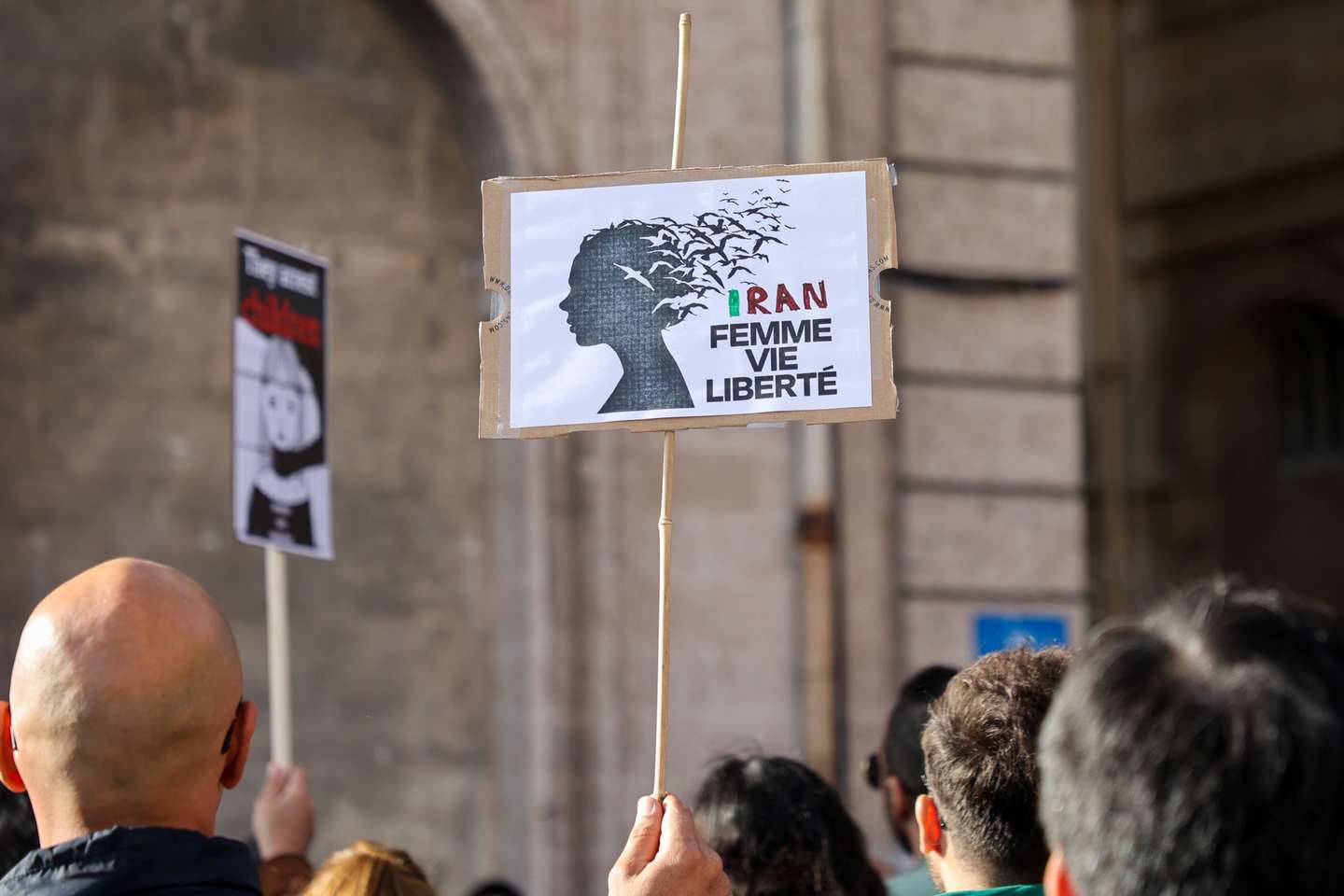 A protester holds a placard in solidarity with the Iranian