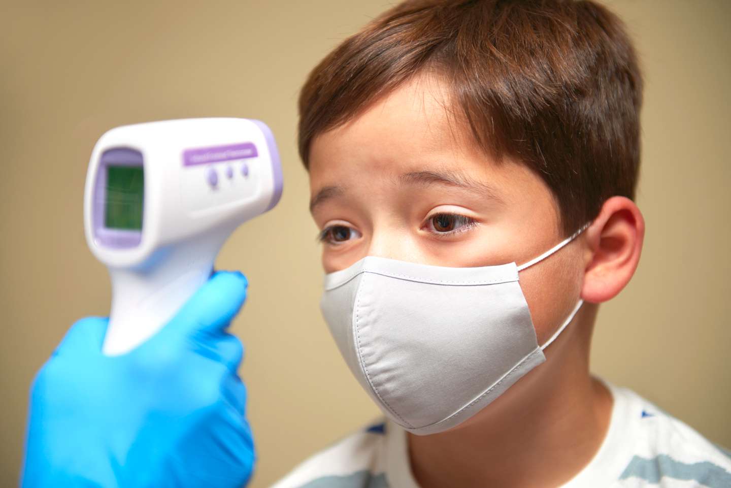 9 year old boy having temperature taken, during covid-19 test