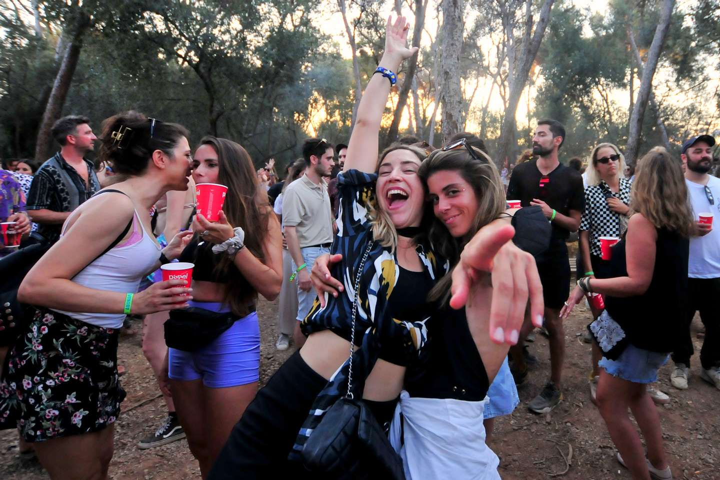 A group of people dance and drink without face masks at the