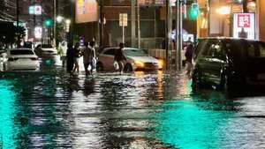 epa13166815 People walk in a flooded road following heavy rain in Ichikawa, Chiba prefecture, near Tokyo, Japan, 13 August 2026. Southern Kanto was hit by localized torrential rain and the Japan Meteorological Agency issued its highest-level 5 emergency heavy rain warning for parts of Chiba Prefecture.  EPA/JIJI PRESS JAPAN OUT EDITORIAL USE ONLY/