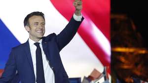 epa09907427 French President Emmanuel Macron and his wife Brigitte Macron celebrate on the stage after winning the second round of the French presidential elections at the Champs-de-Mars after Emmanuel Macron won the second round of the French presidential elections in Paris, France, 24 April 2022. Emmanuel Macron defeated Marine Le Pen in the final round of France's presidential election, with exit polls indicating that Macron is leading with approximately 58 percent of the vote.  EPA/YOAN VALAT
