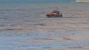 Um barco salva-vidas e a corveta da Marinha NRP João Roby participam nas buscas dos três tripulantes de uma embarcação desaparecida na sexta-feira ao largo na Nazaré, na Praia do Pedrogão em Leiria. PAULO CUNHA/LUSA