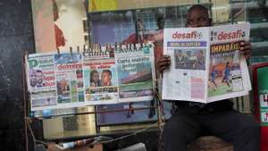Um ardina lê um jornal enquanto espera por clientes, em Maputo, Moçambique, 03 de novembro de 2025. Ardinas de Maputo, na capital moçambicana, viram a venda de jornais a “baixar” depois da pandemia da covid-19, com a internet a “matar o negócio”, chegando a passar um dia sem vender um exemplar. (ACOMPANHA TEXTO DA LUSA DE 10 DE NOVEMBRO DE 2025). LUÍSA NHANTUMBO/LUSA