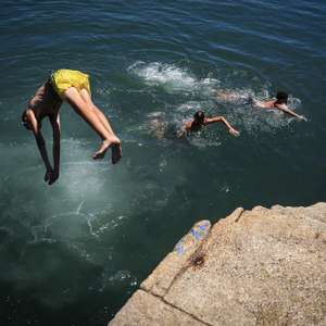 Rapazes mergulham no rio Douro no Porto, 1 de julho de 2026.O tempo quente que afeta Portugal dará origem a uma onda de calor que se prolongará por oito a 10 dias e atingirá praticamente todo o país, estimou hoje o Instituto Português do Mar e da Atmosfera (IPMA).  JOSÉ COELHO/LUSA