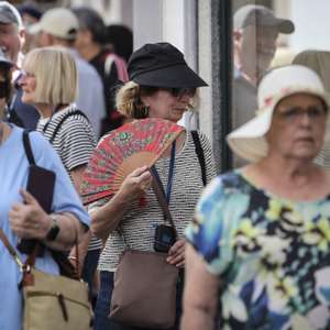 Uma turista usa um leque para se refrescar enquanto passeia no centro histórico de Évora, numa altura em que já se registava temperatura acima dos 35 graus centígrados, Évora, 27 de maio de 2026. O IPMA prevê continuação de temperaturas elevadas para os próximos dias para várias regiões do país com perigo de incêndio muito elevado. NUNO VEIGA/LUSA