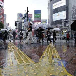 epa13251186 Pedestrians with umbrellas walk at Shibuya crossing under rainfall in Tokyo, Japan, 20 September 2026. Powerful Typhoon Dujuan is expected to approach eastern Japan, including the Tokyo area, bringing torrential rain. The Japan Meteorological Agency warned that some areas could receive a month’s worth of September rainfall in a single day.  EPA/FRANCK ROBICHON