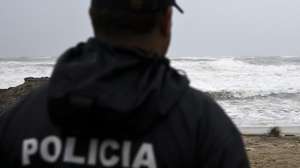 Um elemento da Polícia Marítima observa um helicóptero da Força Aérea