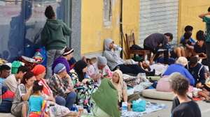 epa13148244 Migrants who entered Ceuta by swimming or on foot from Morocco sit on a street in Ceuta, Spain, 03 August 2026. Surveillance along the Tarajal border, both at sea and on land, as well as new containment measures in the area, including the installation of a barrier in the sea, have reduced the number of people swimming across from Morocco to a minimum.  EPA/REDUAN