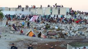 epa13197642 Migrants gather at an encampment as people take part in a rally protesting the migration crisis in Ceuta, Spain, 28 August 2026. The Ceuta Unida platform organized the protest.  EPA/REDUAN