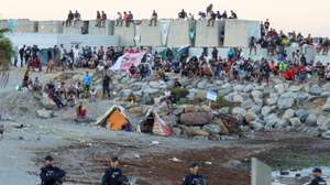 epa13197642 Migrants gather at an encampment as people take part in a rally protesting the migration crisis in Ceuta, Spain, 28 August 2026. The Ceuta Unida platform organized the protest.  EPA/REDUAN