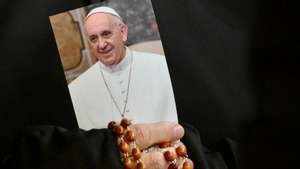 epaselect epa11938675 A nun holds a picture of Pope Francis and a rosary as faithful attend a Rosary prayer for the health of the pontiff at St. Peter's Square in Vatican City, 03 March 2025. Pope Francis was admitted to the Agostino Gemelli Hospital in Rome on 14 February 2025 due to a respiratory tract infection.  EPA/ALESSANDRO DI MEO