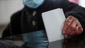 Uma eleitora coloca o seu voto na urna na secção de voto da freguesia de Bencatel, cuja população se tem mostrado descontente devido ao corte da estrada N254, o principal acesso à sede de concelho, Vila Viçosa, 24 de janeiro de 2021.  Mais de 10 milhoes de portugueses  estão inscritos  nestas eleições presidenciais, que se realizam em plena epidemia de covid-19 em Portugal,concorrem  sete candidatos: Marisa Matias (apoiada pelo Bloco de Esquerda), Marcelo Rebelo de Sousa (PSD e CDS/PP) Tiago Mayan Gonçalves (Iniciativa Liberal), André Ventura (Chega), o ex-militante do PS Vitorino Silva, mais conhecido por Tino de Rans e presidente do RIR - Reagir, Incluir, Reciclar, João Ferreira (PCP e PEV) e a militante do PS Ana Gomes (PAN e Livre). NUNO VEIGA/LUSA